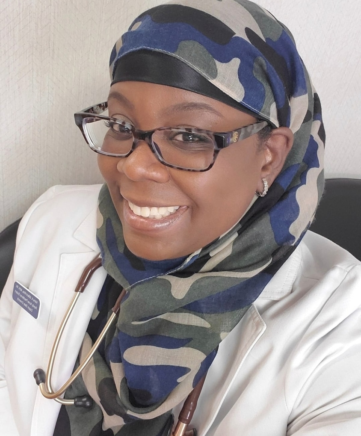 Smiling doctor in hijab with stethoscope.
