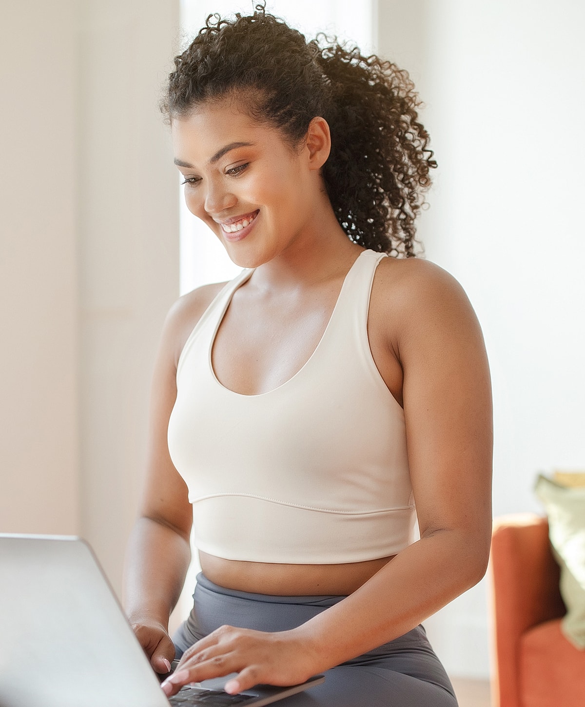 Woman smiling while working on a laptop.