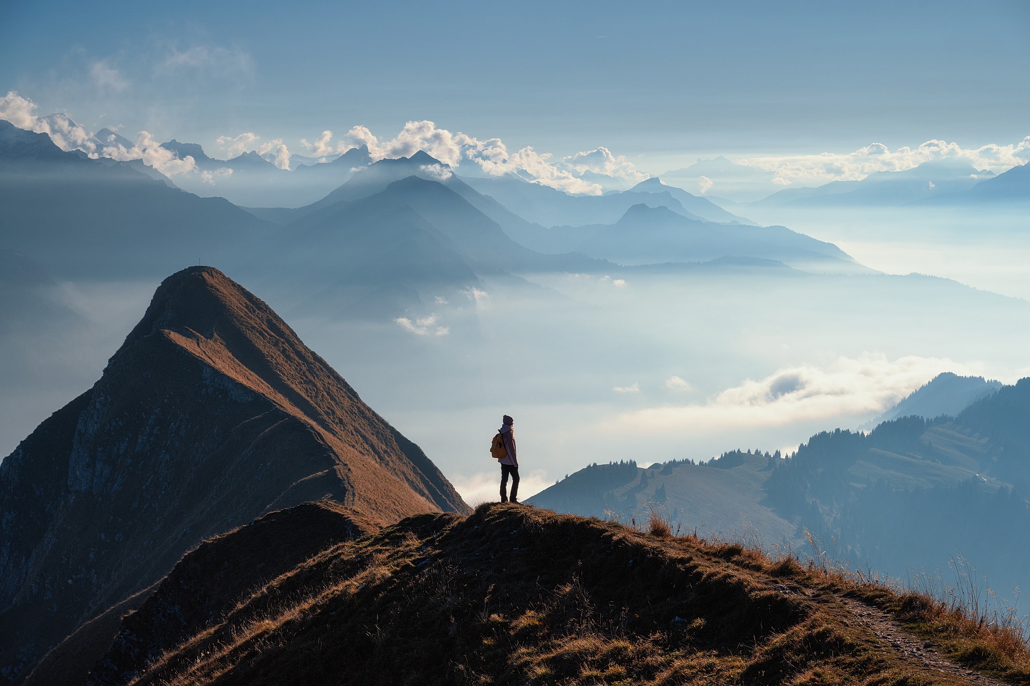 Hiker overlooking a majestic mountain landscape.