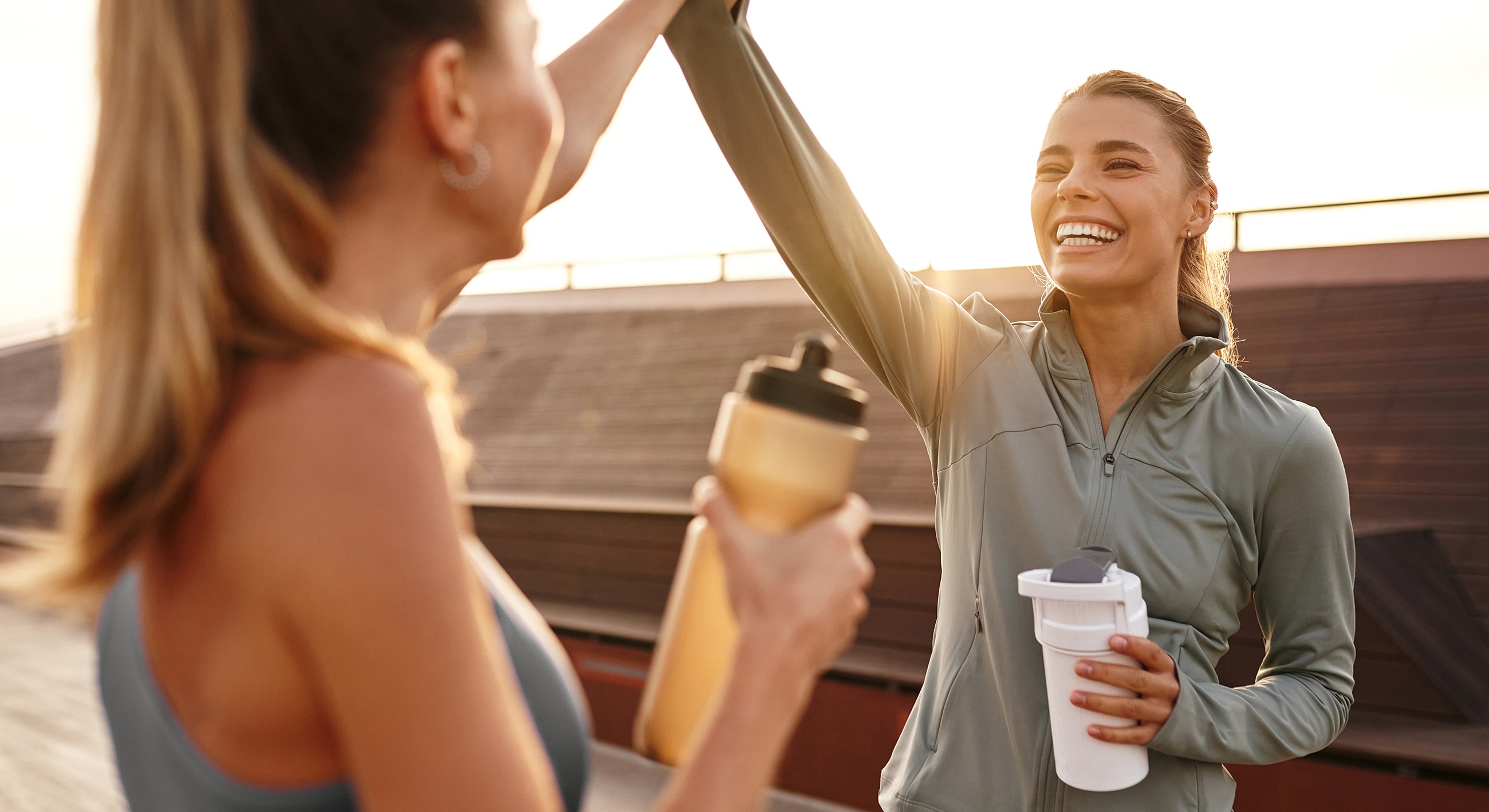 Friends celebrating after workout with protein shakes.