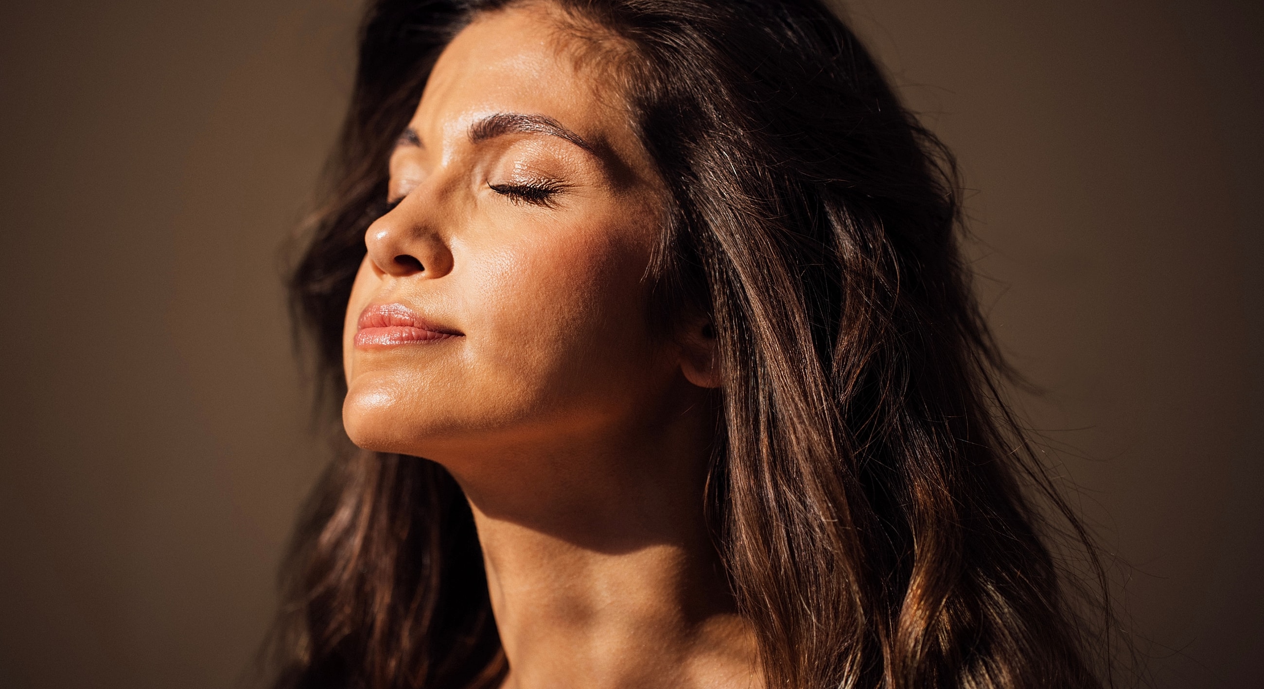 Woman with closed eyes enjoying sunlight glow