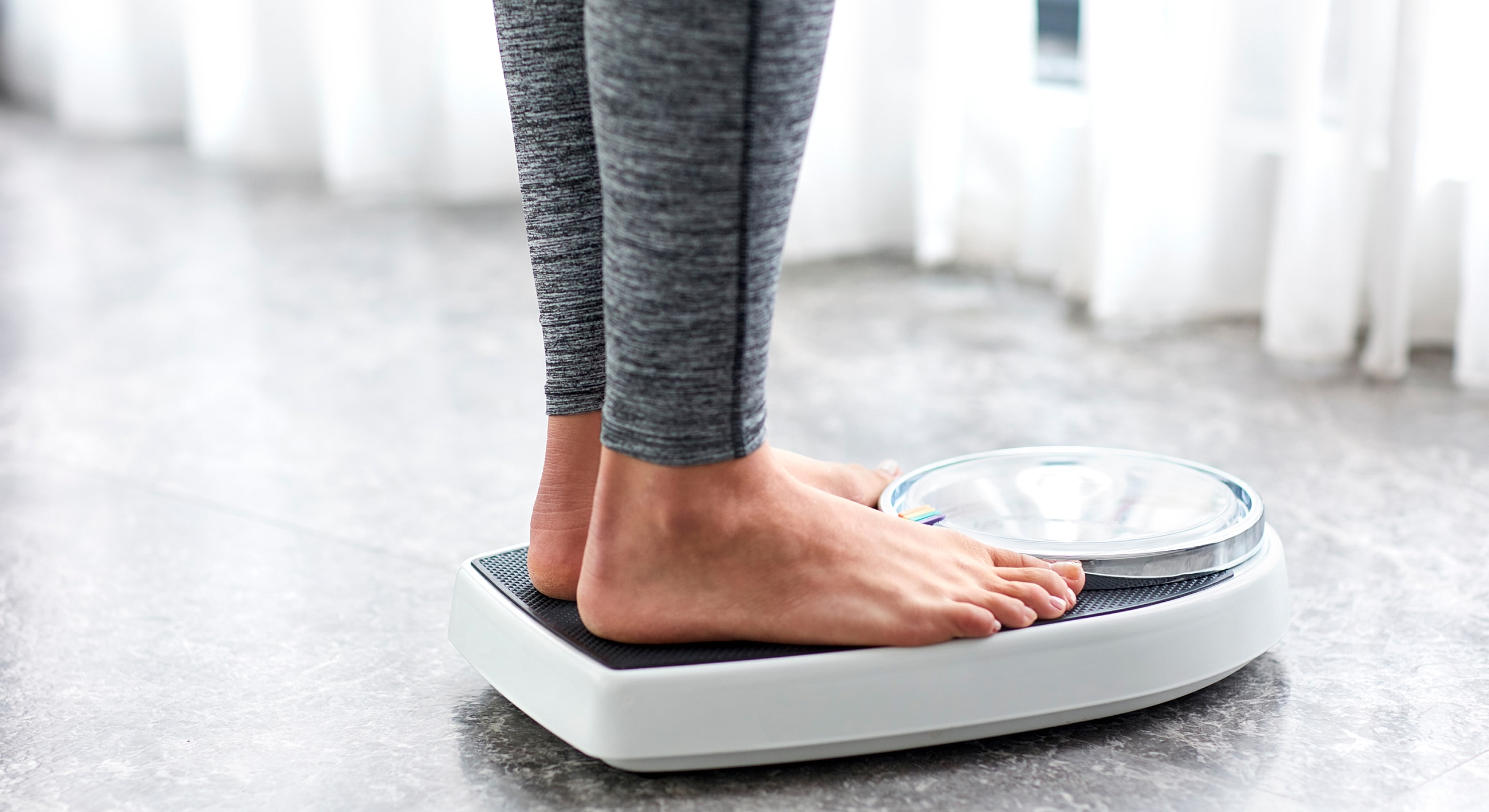 Person weighing themselves on a scale